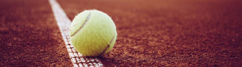 Asche-Tennisplatz mit einem Tennisball auf der Grundlinie